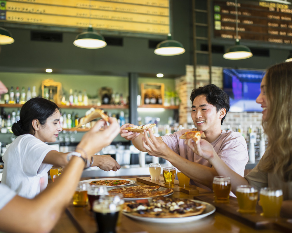 friends enjoying dining out with pizza